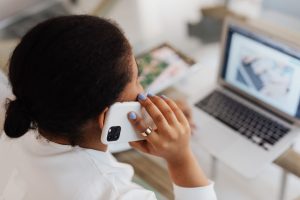 Person reviewing financial documents while managing debt stress and collection call concerns
