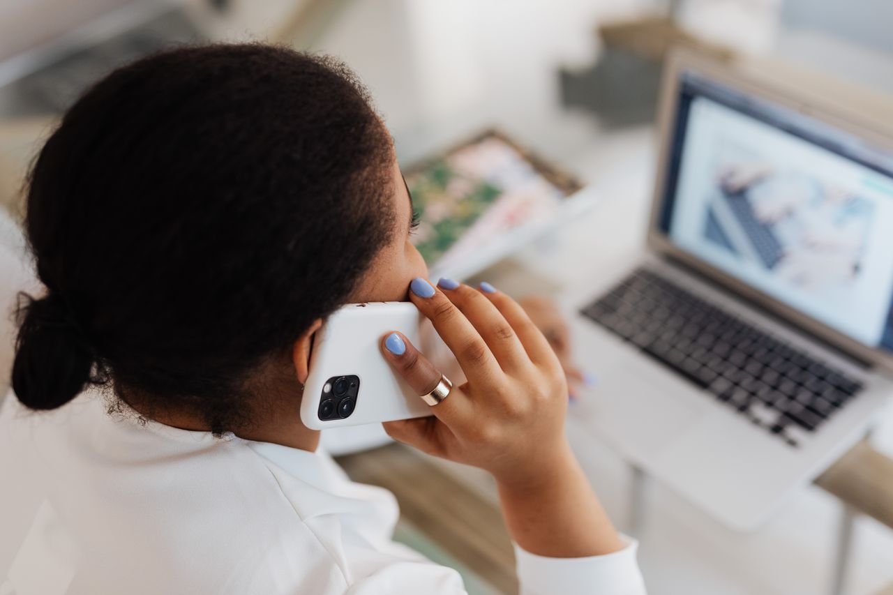 Person reviewing financial documents while managing debt stress and collection call concerns