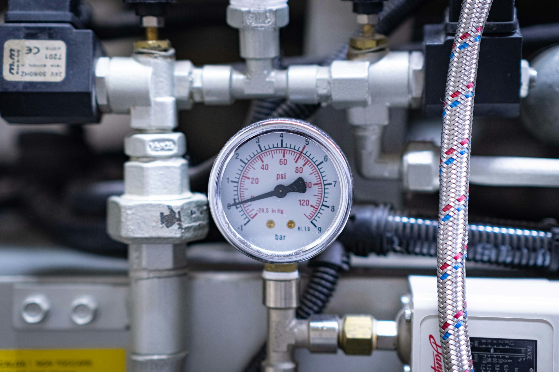 Air compressor gauges showing pressure and operating levels